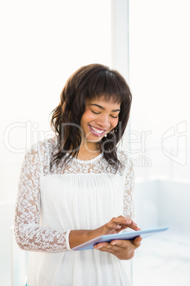 Smiling woman using her tablet in living room