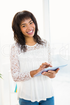 Smiling woman using her tablet in living room