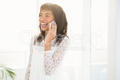 Smiling woman having a phone call in living room