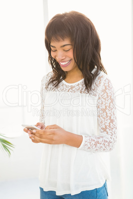 Smiling woman texting on her smartphone