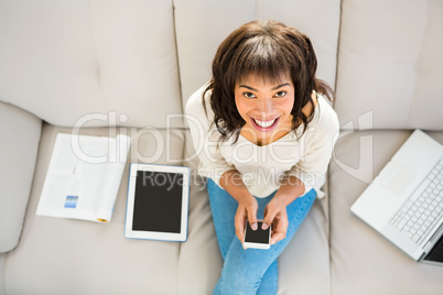 Smiling woman texting on her smartphone