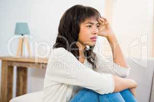 Stressed woman holding her head on couch