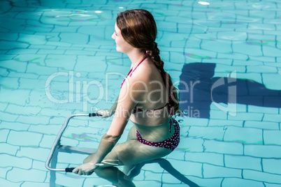 Fit woman cycling in the pool