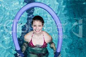 Fit woman doing aqua aerobics with foam rollers