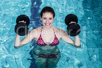 Smiling fit woman doing aqua aerobics