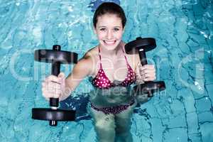 Smiling fit woman doing aqua aerobics