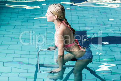 Fit woman cycling in the pool