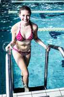 Smiling woman getting out the pool