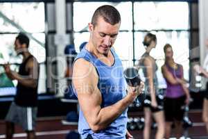 Fit man lifting black dumbbells