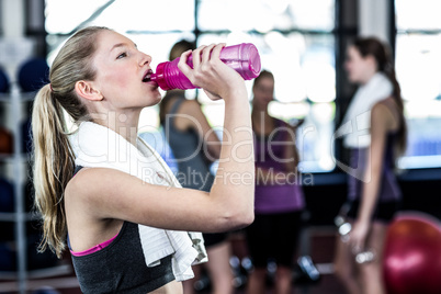 Blonde woman drinking water after working out