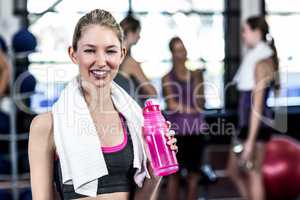 Smiling woman with bottle of water posing