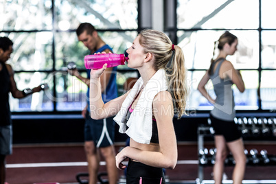 Blonde woman drinking water after working out