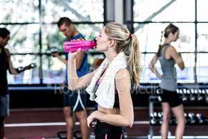 Blonde woman drinking water after working out