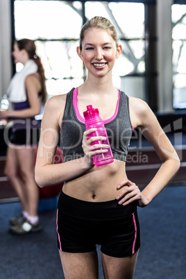 Smiling woman with bottle of water posing