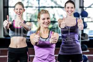 Smiling women posing together with thumbs up