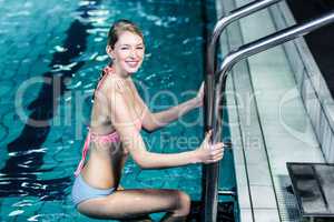 Smiling woman getting out the pool