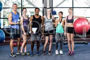 Smiling fitness class posing together