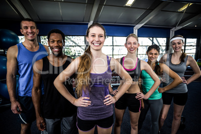 Smiling fitness class posing together with hands on hips Smiling fitness class posing together with hands on hips