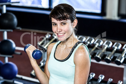 Fit woman exercising with dumbbells