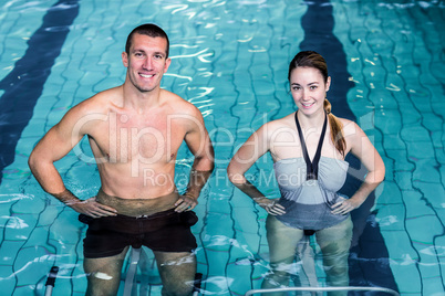 Smiling couple doing aqua aerobics