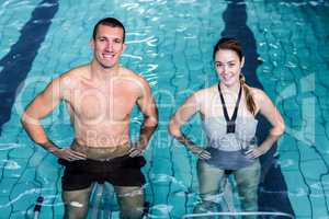 Smiling couple doing aqua aerobics