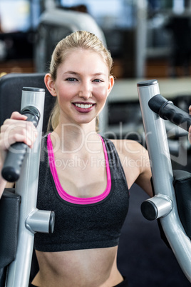 Fit woman using exercise machine