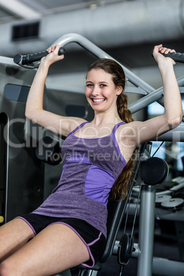 Fit woman using exercise machine