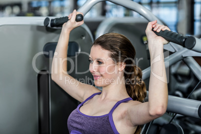 Fit woman using exercise machine