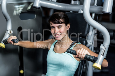 Fit woman using exercise machine