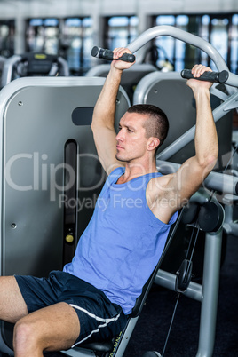 Serious man using exercise machine