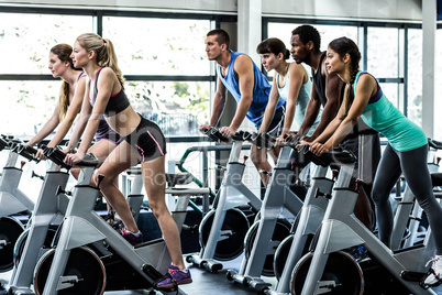 Fit people working out at spinning class