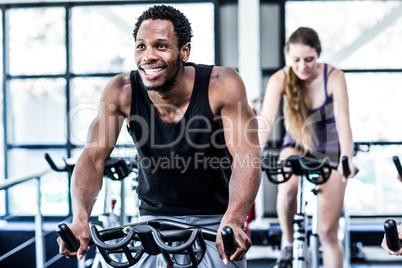 Fit man working out at spinning class