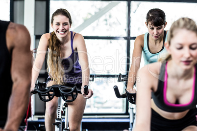 Fit women working out at spinning class