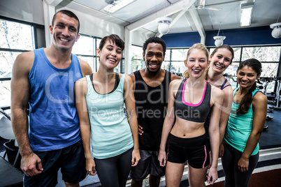 Smiling fitness class posing together