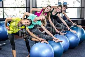 Fit smiling group doing exercise with exercise balls