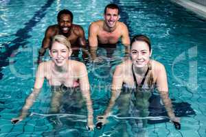 Fit smiling group pedaling on swimming bike