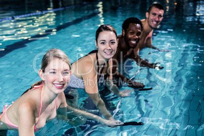 Fit smiling group pedaling on swimming bike