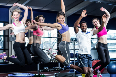 Fit group smiling and jumping