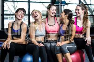 Group of fit woman smiling while sitting on exercise balls