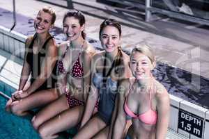 Happy group of women sitting poolside