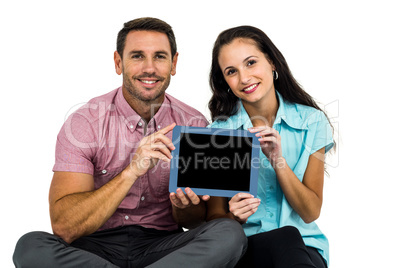 Smiling couple showing tablet at the camera