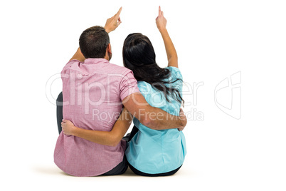 Rear view of couple sitting and pointing somewhere