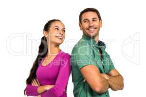 Smiling couple standing back to back with arms crossed