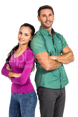 Smiling couple standing back to back with arms crossed looking a