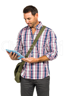 Smiling man with shoulder bag using tablet