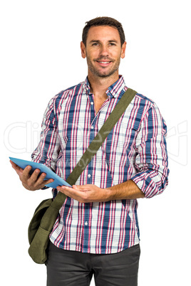 Smiling man with shoulder bag using tablet and looking at the ca