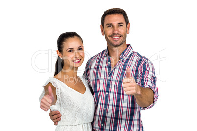 Smiling couple showing thumbs up at camera