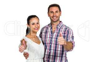 Smiling couple showing thumbs up at camera