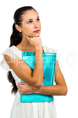 Thoughtful woman holding plastic folder with fist on chin