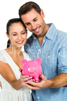 Happy couple holding piggybank Happy couple holding piggybank